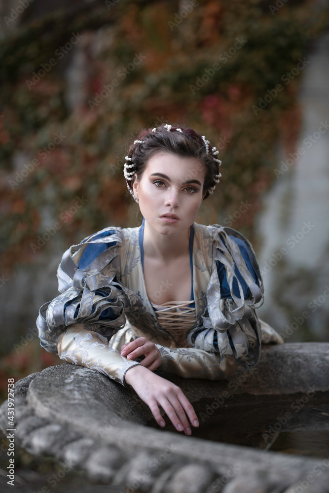 Art photo of a young girl in a medieval dress by a stone bowl Stock ...