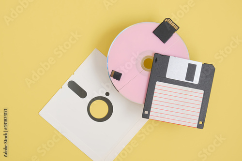 various types of disks for storing information on a yellow background, modern and retro disks and floppy disks