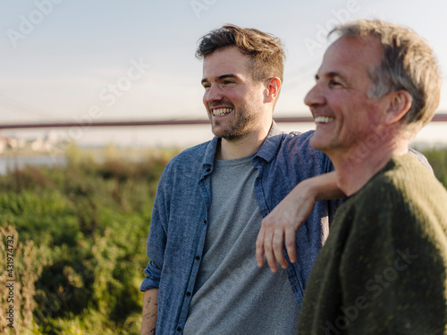 Father and son laughing at riverbank