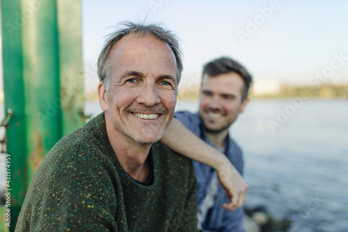 Happy father by son against river