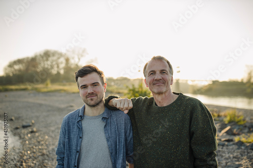 Smiling father and son against clear sky at evening photo