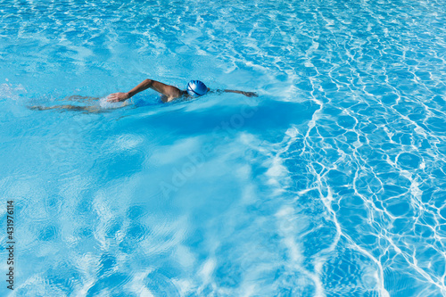 Woman swimming in clear blue swimming pool photo