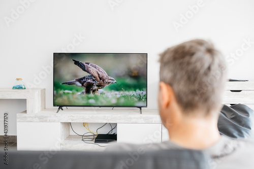 Mature man watching television in living room photo
