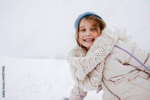 Playful girl smiling in warm clothing during winter