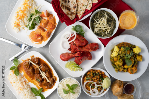 Spread of Indian food including curry, naan, samosa, chicken tikka masala. 