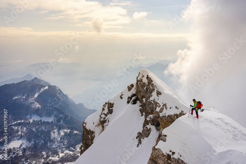 Mountain climber walking on mountain peak against sky
