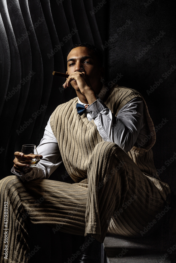 Portrait of a serious young black man smoking a cigar Portrait of a serious young black man smoking a cigar