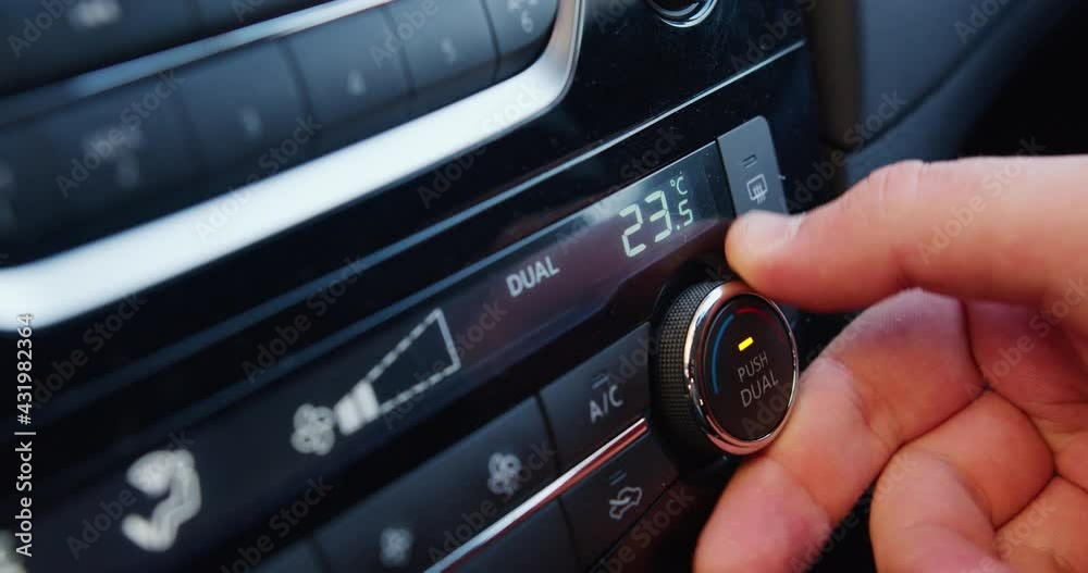 set up air conditioner in the car. Hand turns air conditioner ring. Display indicates temperature inside the car. Cooling air in the car set up air conditioner in the car. Hand turns air conditioner ring. Display indicates temperature inside the car. Cooling air in the car