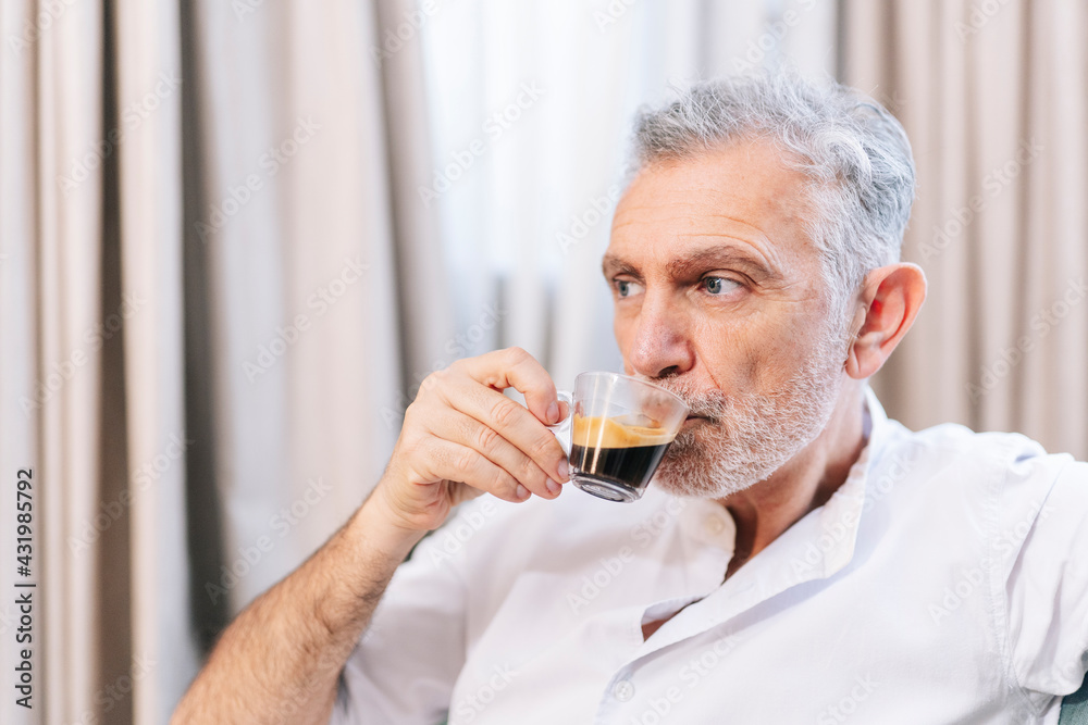 Contemplating man drinking coffee in hotel room Contemplating man drinking coffee in hotel room