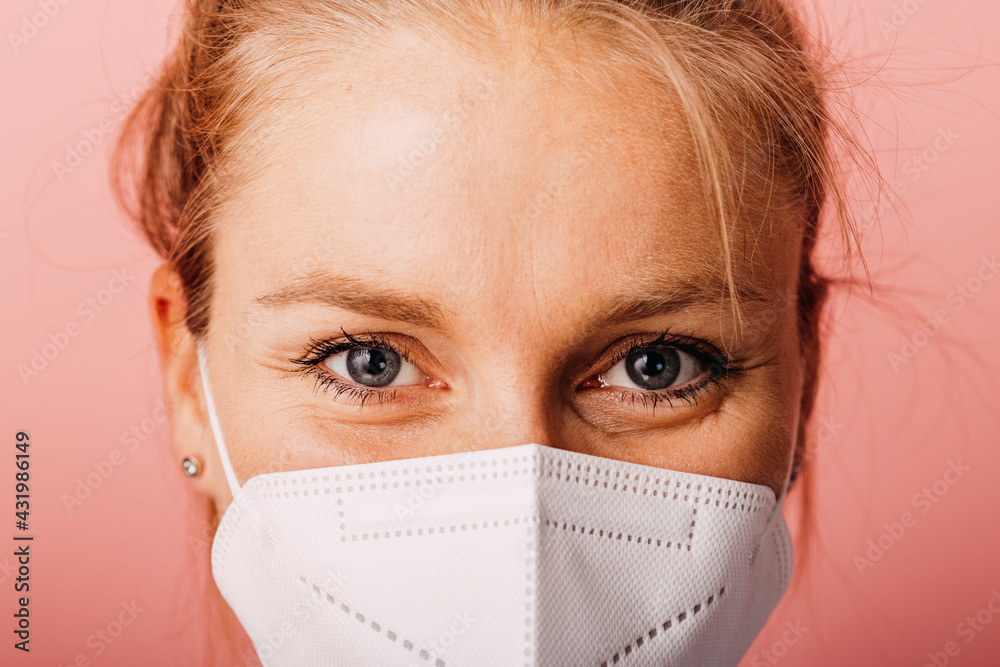 Close-up of woman wearing protective face mask against colored background Close-up of woman wearing protective face mask against colored background