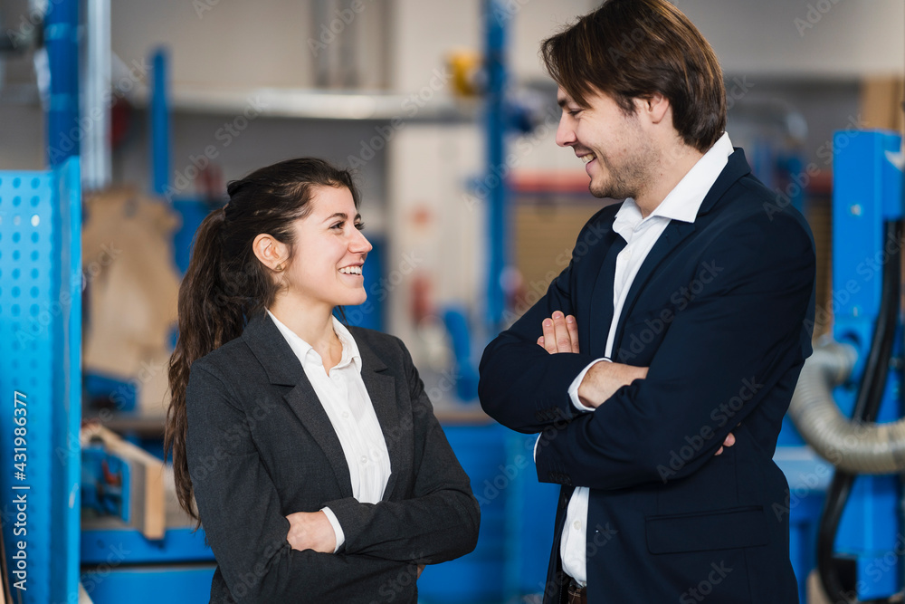 Young business people smiling while standing at industry Young business people smiling while standing at industry
