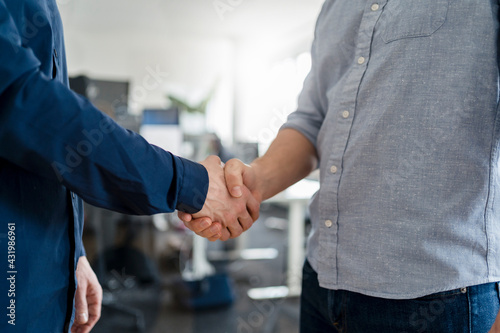 Male entrepreneurs shaking hands at office