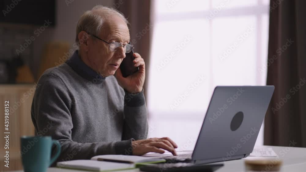 old grey haired man is working at home office, accountant is calling by cell phone, talking with colleagues or clients old grey haired man is working at home office, accountant is calling by cell phone, talking with colleagues or clients