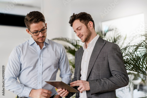 Male entrepreneur discussing with colleague during meeting at office