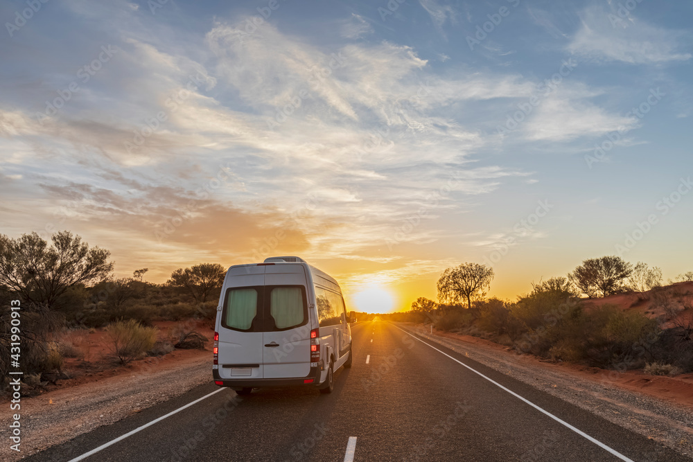 Van driving along Lasseter Highway at sunrise, Australia Van driving along Lasseter Highway at sunrise, Australia