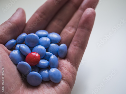 Top view of blue and red chocolate candy in a hand with copy space