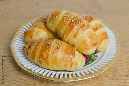 Traditional Serbian homemade rolls with sesame (kiflice) on the vintage plate, close up