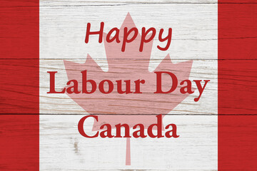 Happy Labour Day Canada message with Canadian maple leaf flag on wood
