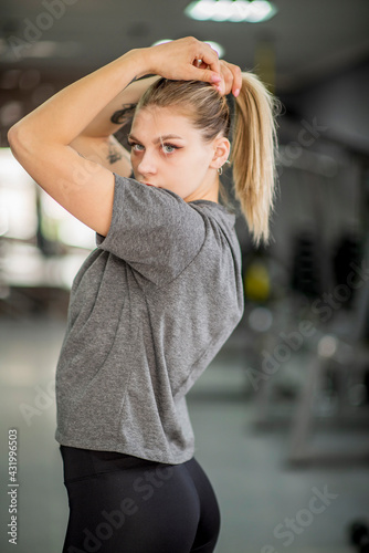 Portrait of a young beautiful athletic blonde in the fitness room.