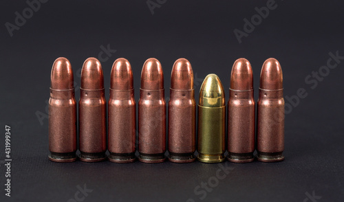 Cuadro en lienzo Bronze pistol bullets with one gold coloured arranged next to each other on blac