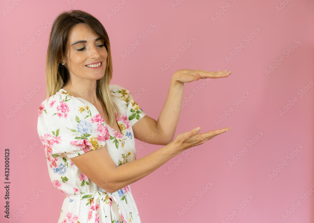 Young caucasian woman posing isolated holding something with both hands, product presentation. Young caucasian woman posing isolated holding something with both hands, product presentation.