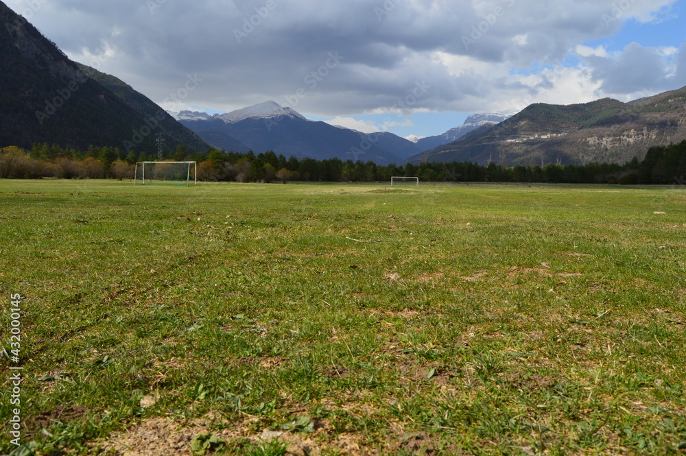 Parque de Llanos de Planduviar en pleno Valle de Broto en Huesca donde se ve extensa pradera con dos porterías de fútbol resguardada por altas montañas nevadas. Parque de Llanos de Planduviar en pleno Valle de Broto en Huesca donde se ve extensa pradera con dos porterías de fútbol resguardada por altas montañas nevadas.