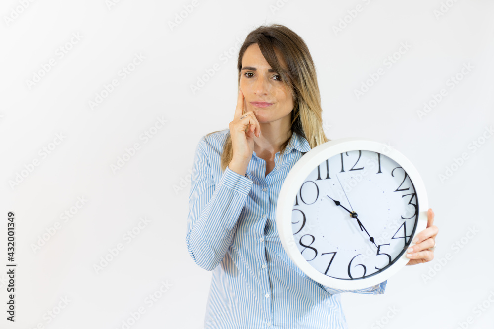 Business woman holding alarm clock with pensive gesture standing over isolated white background. Business woman holding alarm clock with pensive gesture standing over isolated white background.