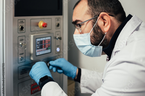 laboratory technician using the nanofiber machine. biochemical experiments for the development of artificial microfibers. photo