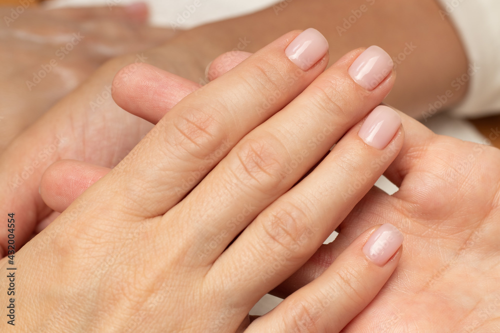 A finished manicure in a beauty salon. Hand close-up, nails, nail polish, color, brush, fingers, manicurist A finished manicure in a beauty salon. Hand close-up, nails, nail polish, color, brush, fingers, manicurist