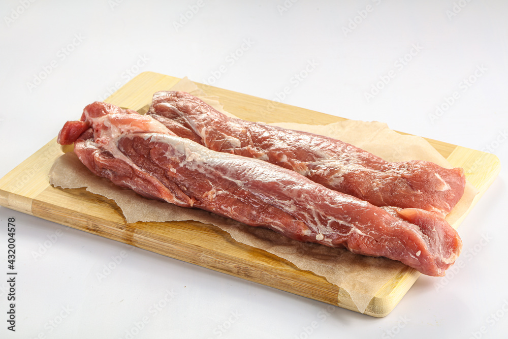 Raw pork tenderloin over board