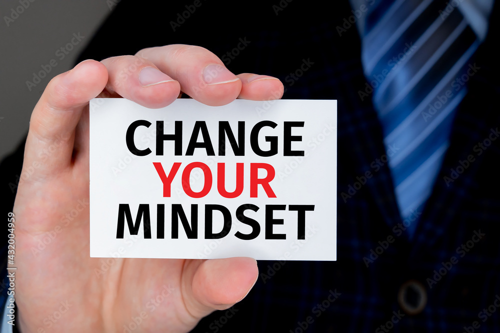 businessman holding a card with text Change Your Mindset businessman holding a card with text Change Your Mindset