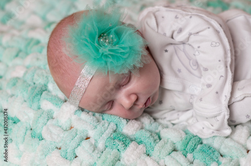 Newborn sleeping baby with the bow - closeup