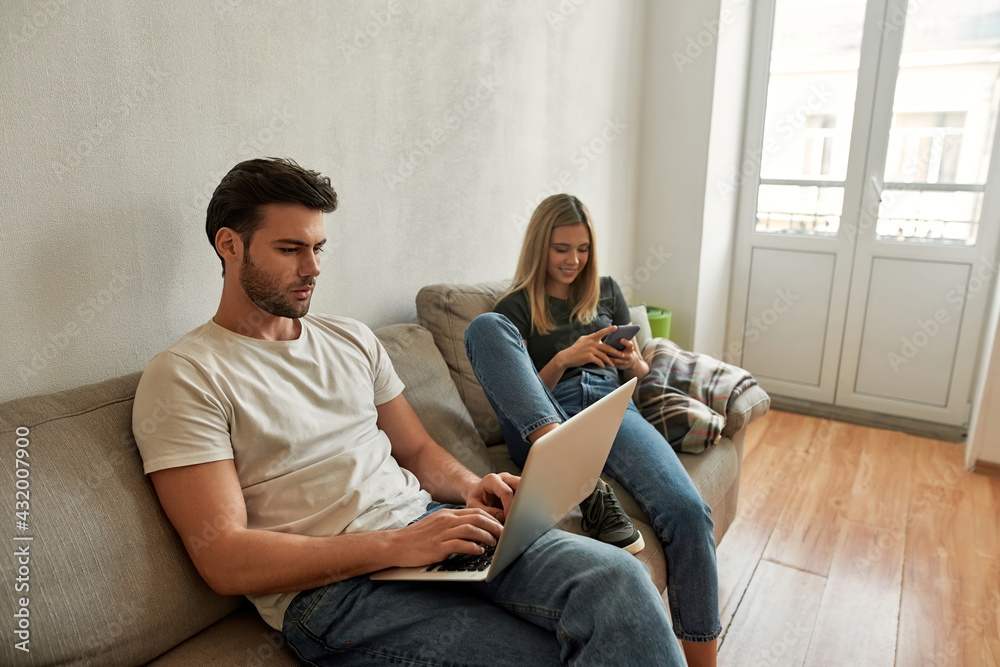 Obraz premium Young sporty man works hardly while his girlfriend watches funny content