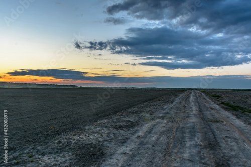 Sunset on an agricultural field prepared for sowing vegetables.