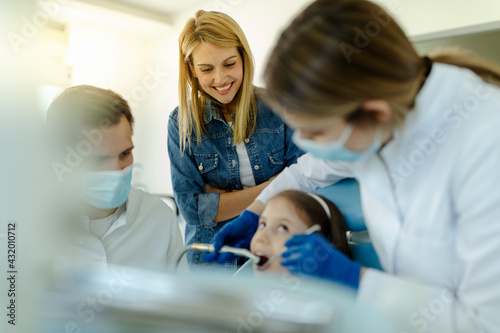 Pediatric dentist examines teeth little cute girl.