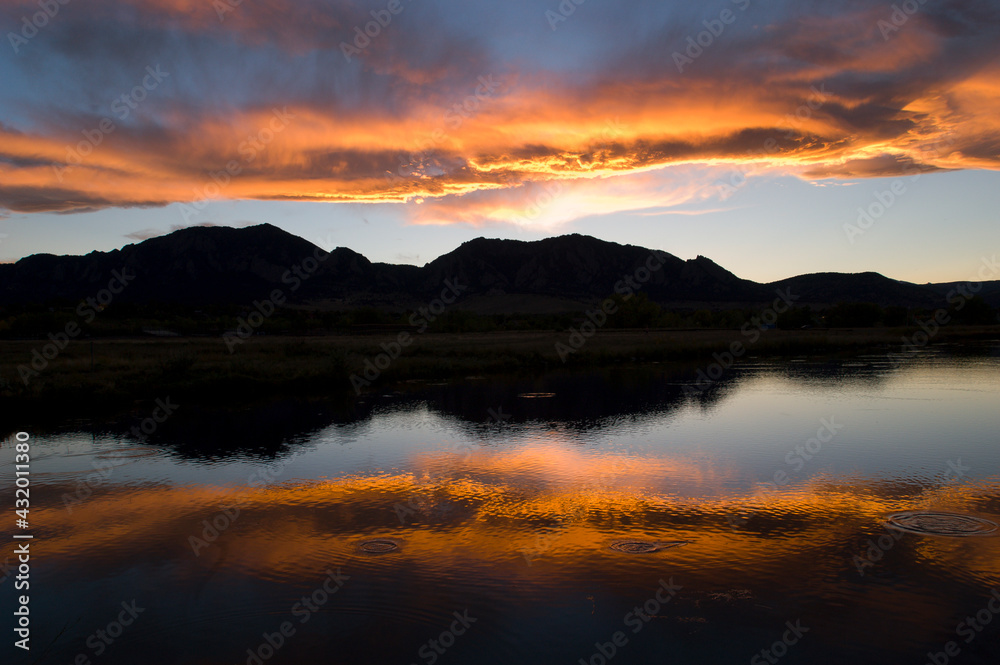 A sunset over the Rocky Mountains is reflected in a lake near Boulder, Colorado A sunset over the Rocky Mountains is reflected in a lake near Boulder, Colorado