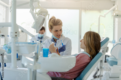 dentist showing on a jaw model how to clean the teeth with toothbrush properly and right.