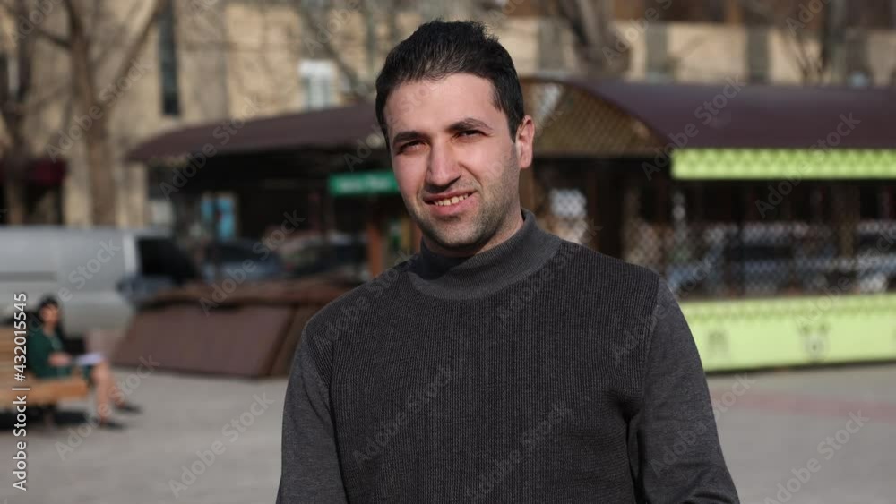 Lifestyle stabilized shot of happy smiling armenian young man enjoying his day in street. Young man posing for camera in street Lifestyle stabilized shot of happy smiling armenian young man enjoying his day in street. Young man posing for camera in street
