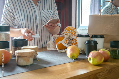 Food delivery home.Contactless delivery service.Online order and payment.Store services in food delivery in quarantine covid.Girl in the kitchen arranges food Zero waste photo