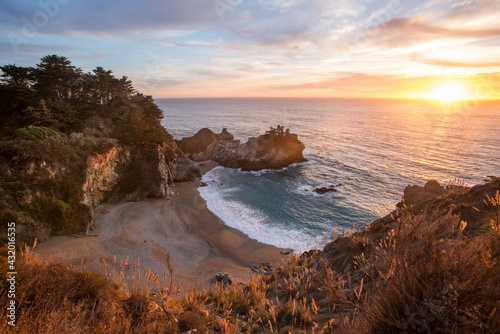 The sun sets in a spectacular fashion as the McWay Falls drop eighty feet down to the sand along California's dramatic Big Sur coast. photo