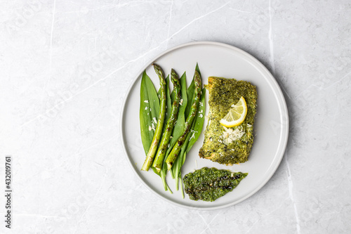 Salmon fillet with green wild garlic pesto. Green asparagus with salmon