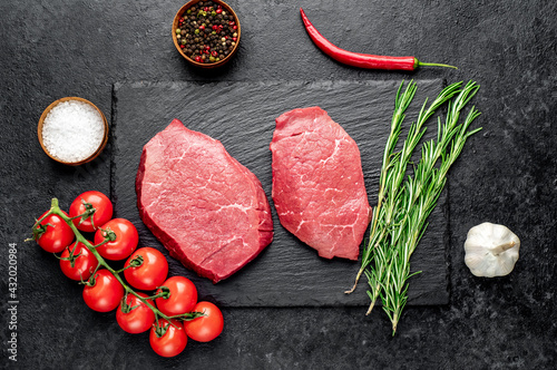 raw beef steak with spices on stone background