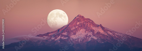 Full moon rising behind Mt Hood in sunset color photo