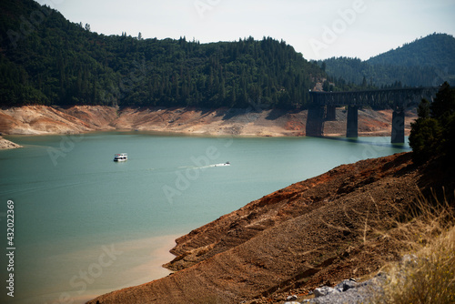 In California's largest reservoir houseboats are dwarfed by the 140 foot bathtub ring around Shasta Lake, California.