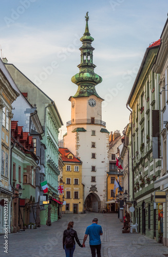 Obraz na płótnie Two People Holding Hands on Empty Michalska Street in Bratislava Old Town During Coronavirus Pandemic with Michael's Tower (Michalska Brana) in Background in Slovakia w salonie