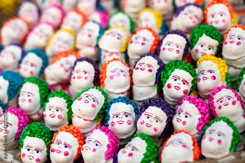 A strange amalgamation of finger like puppets with white painted faces, and colorful hair and cheeks.