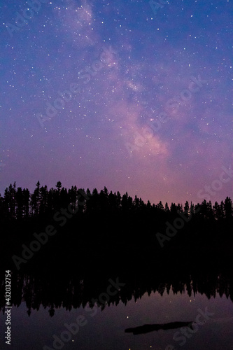 The Milky Way Galaxy extends down onto the horizon above Bearpaw Lake in Grand Teton National Park, Wyoming. photo