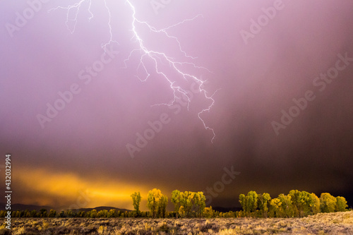 A lightning bolt strikes toward Jackson Hole, Wyoming during a storm. photo