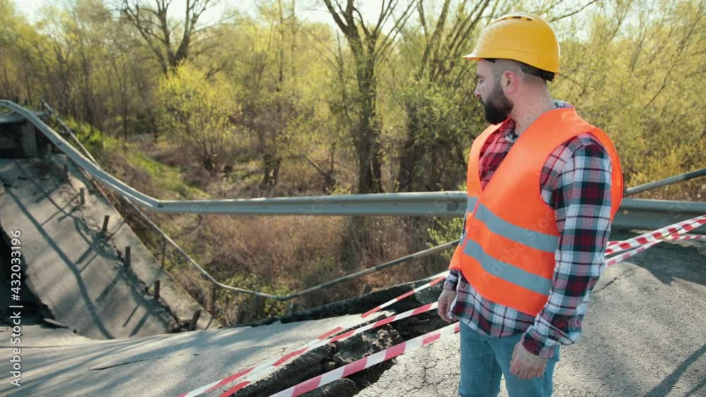 View of the destroyed road bridge as consequences a natural disaster. Large bridge. Destruction of canvas, collapse of the bridge structure. Engineer in hardhat audit natural disaster View of the destroyed road bridge as consequences a natural disaster. Large bridge. Destruction of canvas, collapse of the bridge structure. Engineer in hardhat audit natural disaster
