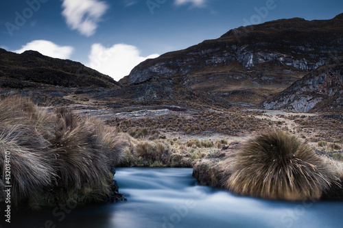 A long exposure as the river and sky match blue and white hues in a soft and surreal landscape in the Cordillera Huayhuash of the Andes Mountains in Peru.